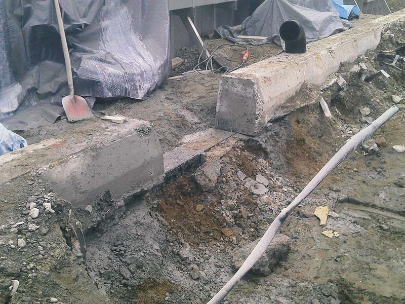 Abgetrenntes Betonfundament in einer Baugrube nach Säge- und Rückbauarbeiten