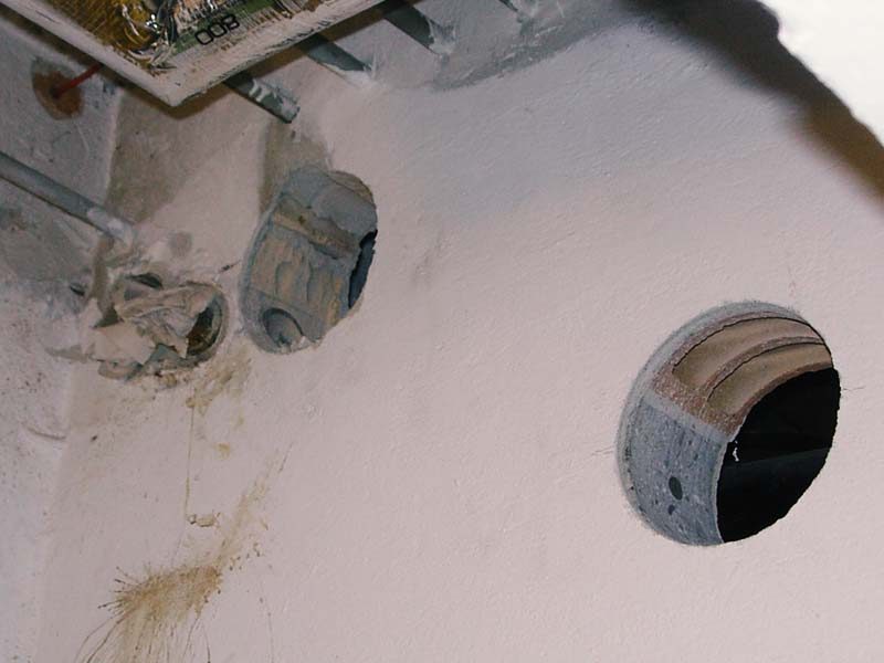 Kernbohrung mit glatter Kante in einer Kellerwand neben bestehenden Leitungsdurchführungen